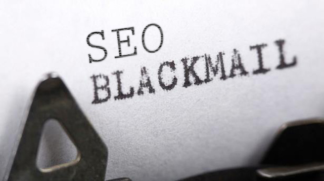 Close-up of a sheet of paper in a typewriter with the words SEO BLACKMAIL typed on it